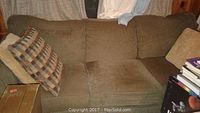 Front view of mocha brown fabric couch showing seat cushions and pillows.