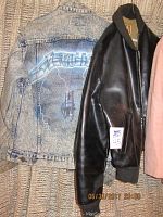 1990s Metallica stonewashed denim jacket and Levi Strauss vinyl bomber jacket hanging on a textured wall.