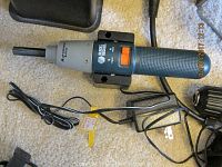 Black & Decker automatic electric screwdriver with power cord and charger on carpet