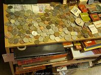 Photo of coin collection book showing quarters and various loose coins on table with multiple matchbooks.