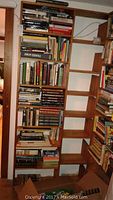 Photo of tall wooden bookshelf filled with numerous books stacked both vertically and horizontally, showing a wide variety of books across different subjects including science and literature.