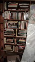 Full bookcase filled with multiple shelves of books including vintage nonfiction and humor titles.