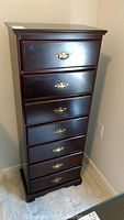 Front view of the narrow tall boy showing all 7 drawers and brass handles.