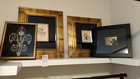 Four framed art pieces displayed on shelves including sketches, jazz painting and rhinestone fleur-de-lis.