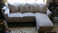 Full view of beige micro-suede sectional sofa with attached right-side chaise