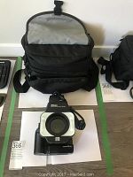 Overview of camera bag behind macro speedlight and lens assembly