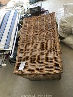 Top view of large rectangular natural wicker basket with hinged lid closed.