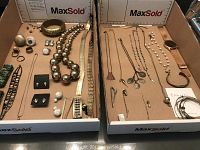 Full view of the two boxes of assorted jewelry pieces on cardboard board.