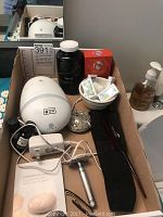 Box with aroma diffuser, essential oils, serum, razor, comb, compact mirror, and hair accessories