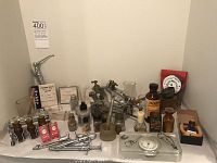 Wide view of assortment on shelf: syringes, articulator, bottles, boxes, clamps