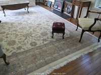 Full view of the large floral patterned area rug under a coffee table and furniture, showing overall design and color.