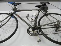 Side view of adult Trek road racing bike showing frame, wheels, pedals, and water bottle on the holder.