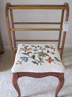 Photo showing the wooden quilt rack and needlepoint stool together, clear view of embroidered floral seat and wood finish on both items.