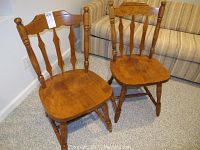 Two matching wooden desk chairs side by side showing full front views and structure.