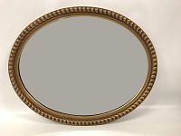 Front view of the oval gilt wood mirror showing gold beaded frame and reflective glass.