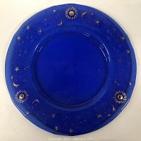 Overhead view of 13-inch blue glass platter showing complete round shape and gilt celestial motifs around edge.
