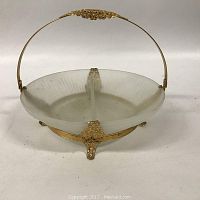 Front view of clear divided glass serving dish with gold metal base and handle