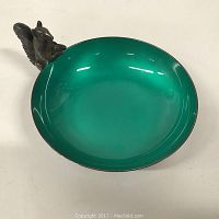 Angle showing teal enamel interior of small nut dish with attached metal squirrel figurine on the rim, detail of enamel finish and squirrel figure.