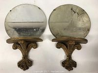 Front view of the pair of painted wood shelves with round mirrors showing the shelves and mirror surfaces.