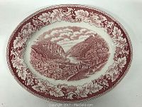 Top view of the cranberry transferware platter showing the detailed Harpers Ferry valley scene in the center with grapevine leaf border.