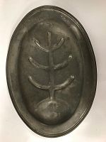 Top view of oval pewter meat platter showing embossed tree-like design on the surface.