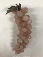 Full view of the pink quartz grape cluster sculpture showing multiple polished gemstone grapes connected together.