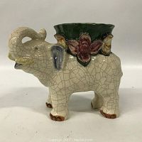 Side view showing the elephant shape, crackle finish, and planter opening with floral detail.