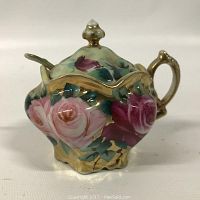 Closed view of the floral mustard pot showing pink and purple flowers, gold trim, and handle.