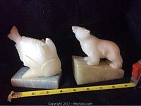 Photo of soapstone fish and bear sculptures side by side showing front and left profile views with measuring tape for scale.