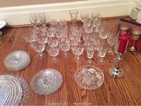 Full view of grouped crystal stemware, bowls, and silver candle holder showing quantity and variety