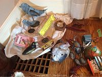 Metal bird sculptures and assorted yard accessories displayed on a fabric-lined surface.