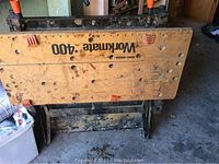 Full view of the Black & Decker Workmate 400 workbench top showing worn wooden surface with printed measurements and holes.