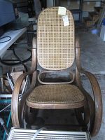Front view of bentwood rocking chair with cane seat and backrest showing wear and scratches.