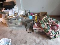 Overall view of all items in the lot including bird water fountain, floral wreaths, and other decor