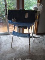 High chair with pack and play on its seat viewed from side