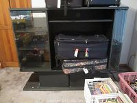 Entertainment center showing the main shelving and storage section with glass doors partly open or visible.