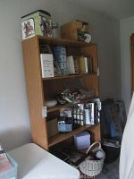 Shelf with assorted crafting items including boxes, scrapbooking supplies, yarn, and basket