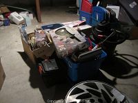 Wide view showing various tools and equipment in bins and boxes, Dirt Devil vacuum, and other items grouped together.