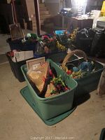 Wide view of storage bins and baskets filled with various holiday decorations including artificial flowers, sombreros, and floral greenery.