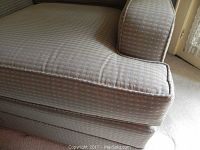 Close-up photo of the chair cushion and armrest showing the fabric pattern and condition.