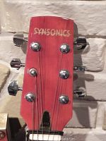 Close-up of the guitar headstock showing the Sysonics brand name and tuning pegs.