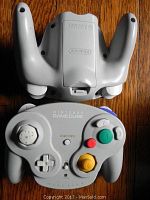Top and bottom view of a gray Nintendo WaveBird wireless controller showing buttons and joystick.