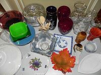 Top-down view of multiple glassware and kitchen items including colorful glass bowls, wooden spoons, and vases.