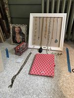Full view of necklaces hanging on white frame, earrings in front, cosmetics bag and organizer on the carpet, 10x12 picture frame on side
