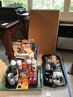 Wide view of lot showing cork board, office supplies like pencils, papers, and spray cans in trays on floor