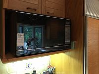 Front view of Sharp Carousel II microwave in black with sensor cooking, showing control panel and reflective door.