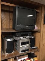 Panasonic CRT television on shelf above stereo system and VCR.