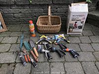 Full view of all gardening tools, hose attachments, insect repellent spray, outdoor fogger, woven basket and sprayer box.