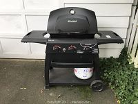Front view of Kenmore Quantum Series propane grill with control knobs, foldable side shelves, and propane tank on bottom shelf.