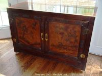 Front view of sideboard showing wood veneer, two Asian motif painted doors, and brass hardware